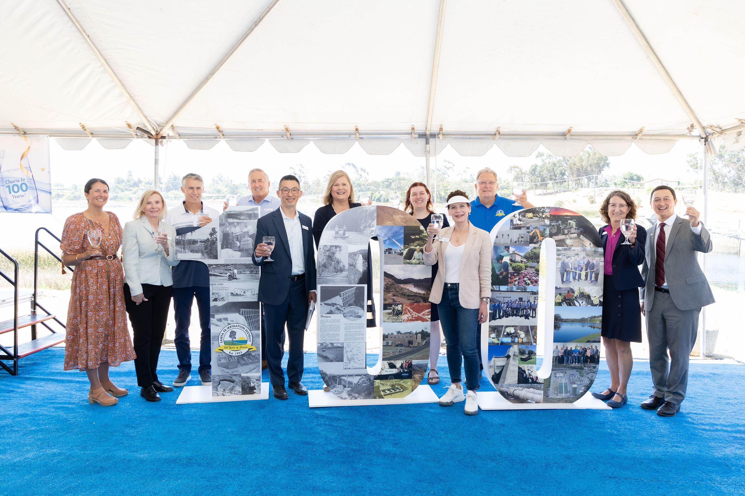SFID board and staff with local elected officials standing in front of 100 sign